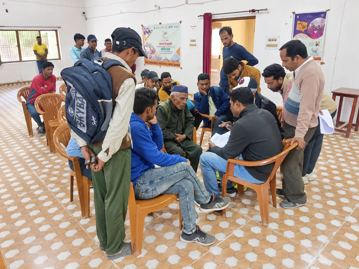 Community members gathered around a seated discussion with papers and shared notes